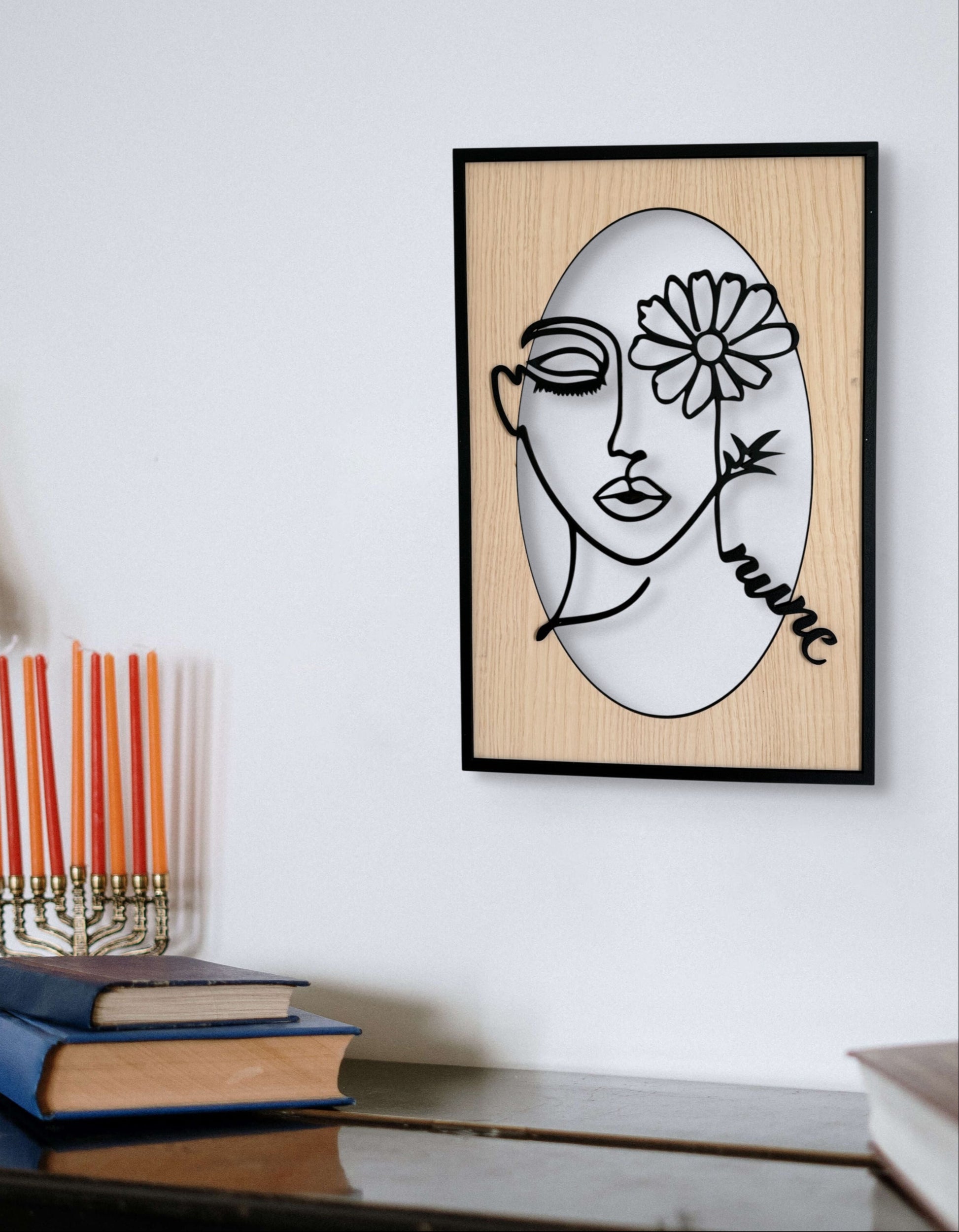 Bloomed Eye wall art in one-line art style featuring a woman’s face with one eye covered by a daisy, drawn in minimalist black lines with natural wood tones. Perfect for floral, modern, and minimalist decor.