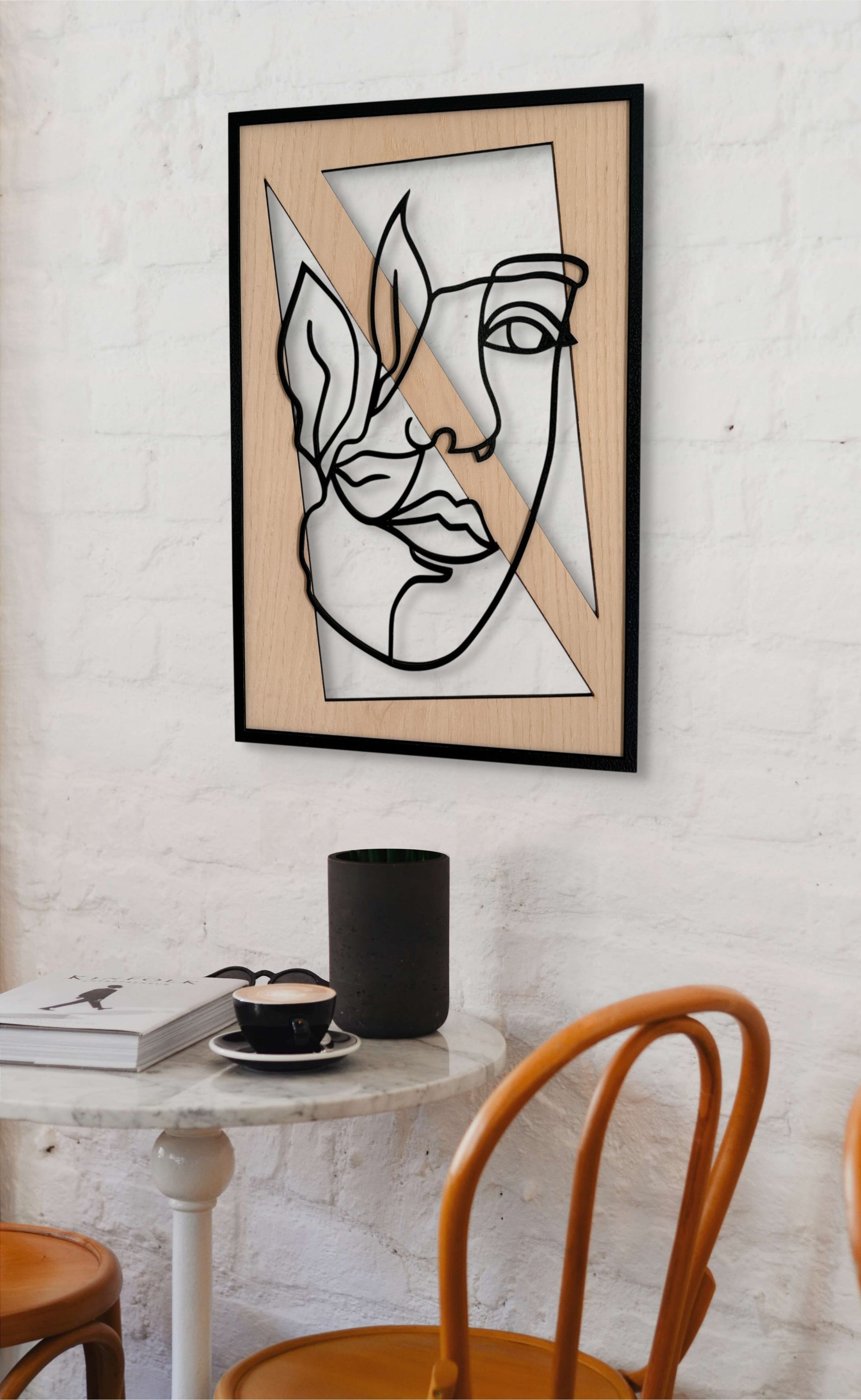 Leafed Gaze wall art in one-line art style featuring a woman’s face partially veiled by three delicate leaves, using minimalist black lines and natural wood tones. Perfect for nature-inspired, modern decor.